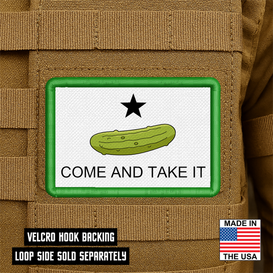 Funny Come and Take It pickle morale patch featuring a green pickle beneath a black star on a white background with green embroidered border attached to a tan tactical backpack.