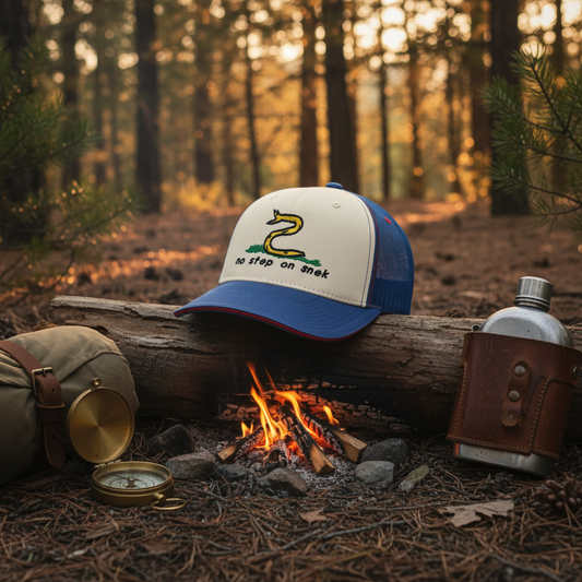 Cap with snake design and 'No step on snake' text in a forest setting with fire and camping gear.