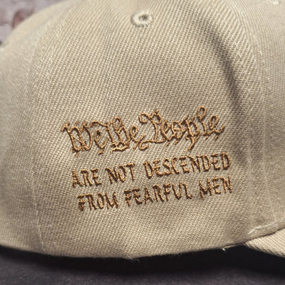 Beige cap with embroidered text on a dark background