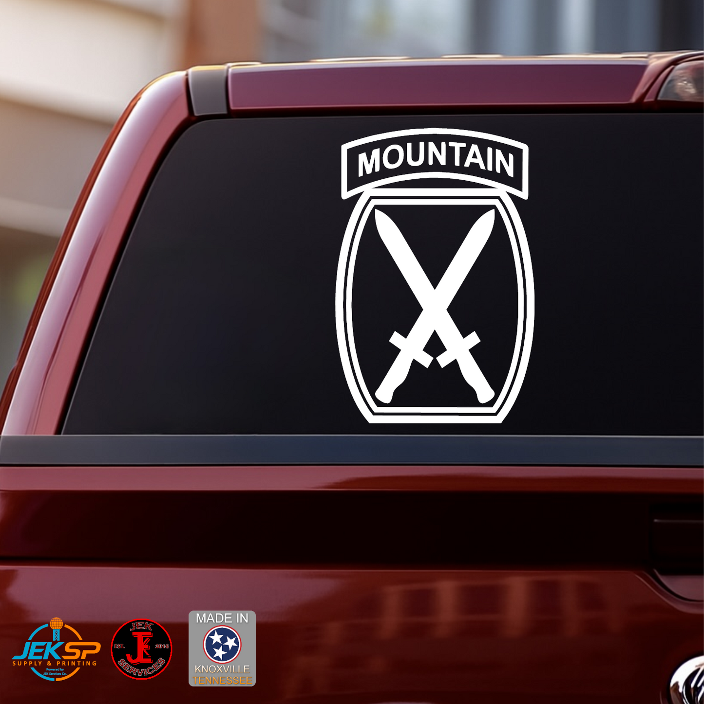 White 10th Mountain Division vinyl decal with Mountain tab and crossed swords insignia displayed on a truck rear window.