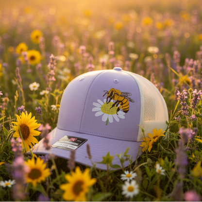 Cap with bee design in a field of flowers at sunset