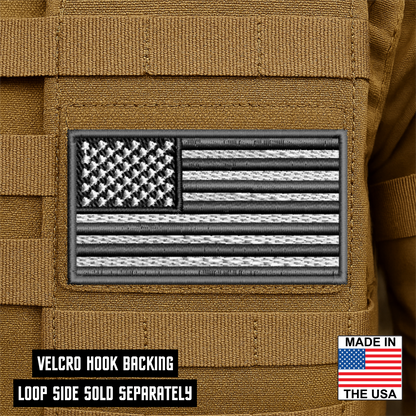 Gray subdued American Flag embroidered tactical morale patch with hook backing attached to tactical vest