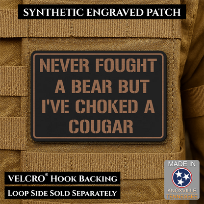 I’ve Choked A Cougar laser-engraved synthetic morale patch: a rectangular synthetic engraved patch with a black background and tan lettering reading “NEVER FOUGHT A BEAR BUT I’VE CHOKED A COUGAR,” shown attached to tan tactical.