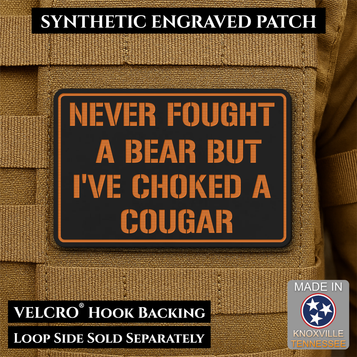 I’ve Choked A Cougar laser-engraved synthetic morale patch: a rectangular black synthetic patch with orange border and orange text reading “NEVER FOUGHT A BEAR BUT I’VE CHOKED A COUGAR,” shown attached to tan tactical fabric. Text.