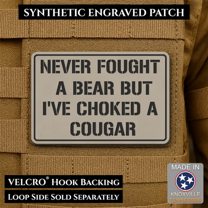 I’ve Choked A Cougar laser-engraved synthetic morale patch: a rectangular synthetic engraved patch with black text on a light gray background, shown attached to tan tactical webbing. Text overlays read 'SYNTHETIC ENGRAVED PATCH,'.