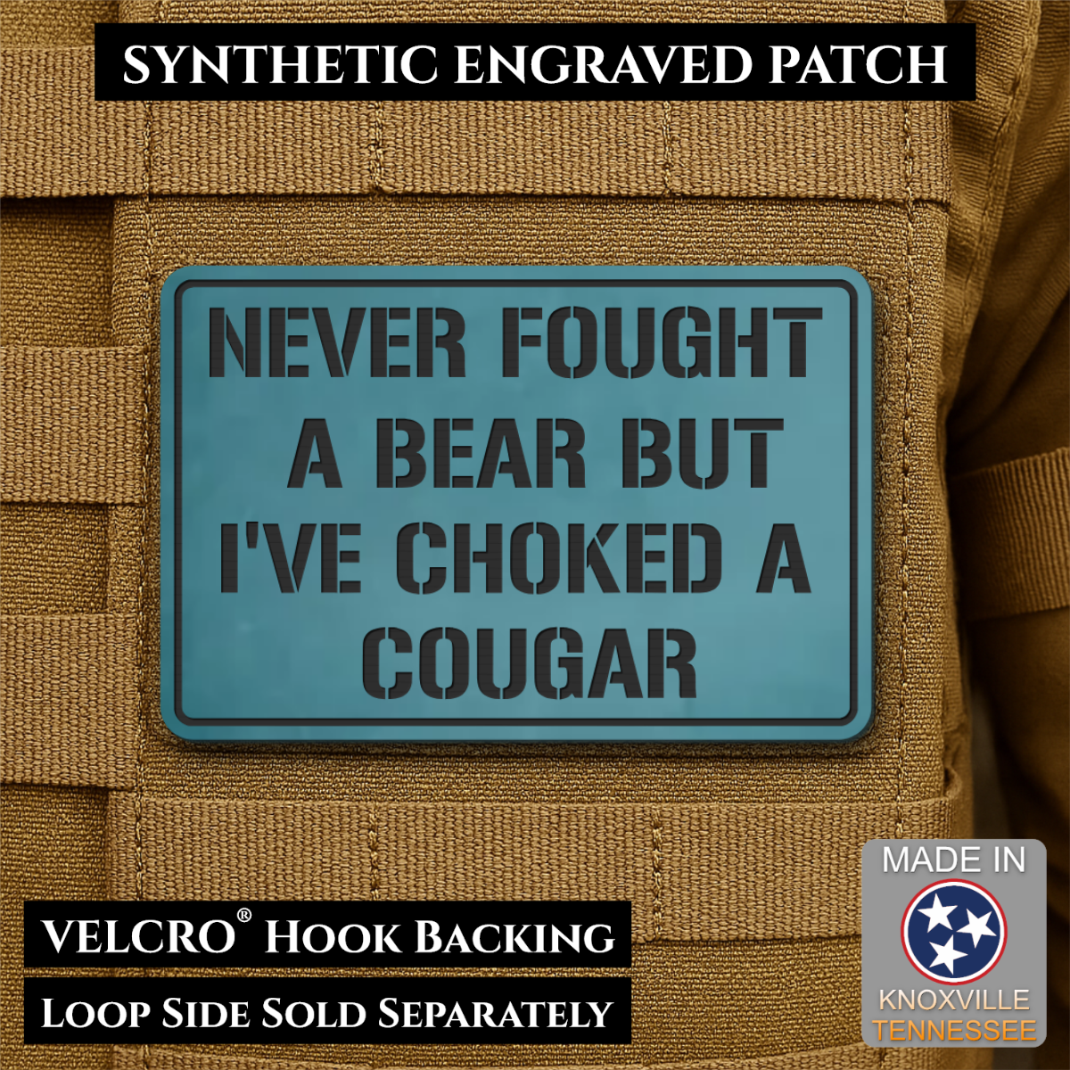 I’ve Choked A Cougar laser-engraved synthetic morale patch: a rectangular synthetic engraved patch with a blue-green background and black text reading 'NEVER FOUGHT A BEAR BUT I'VE CHOKED A COUGAR,' shown attached to tan tactical.