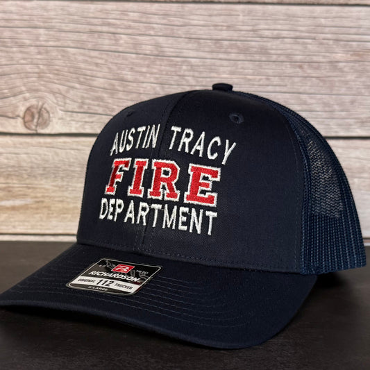 Black cap with 'Austin Tracy Fire Department' text on a wooden background