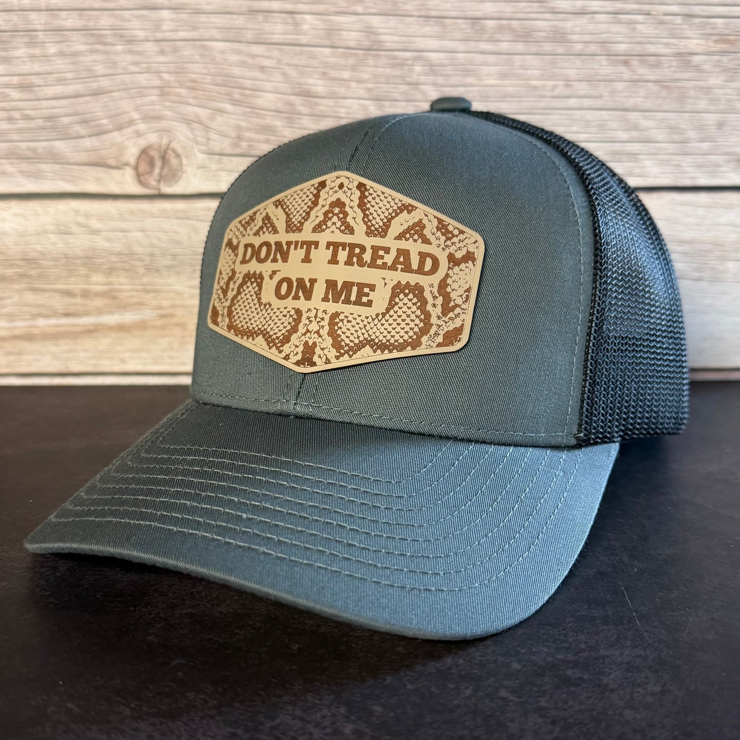 Blue cap with 'Don't Tread on Me' patch on a wooden background