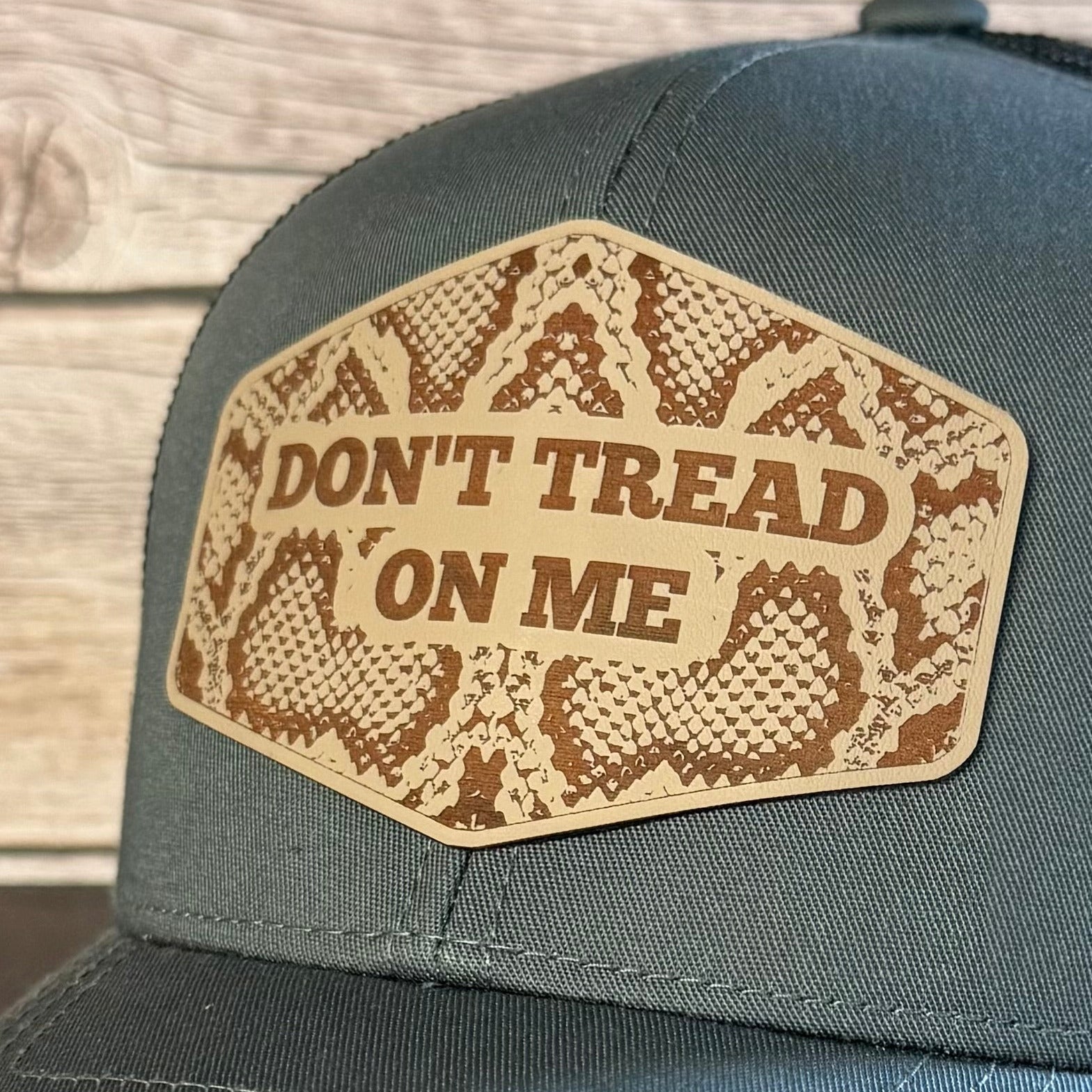 Blue cap with 'Don't Tread on Me' patch on a wooden background