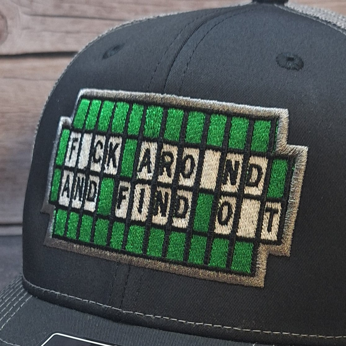 Black cap with a green and white text patch on a wooden surface