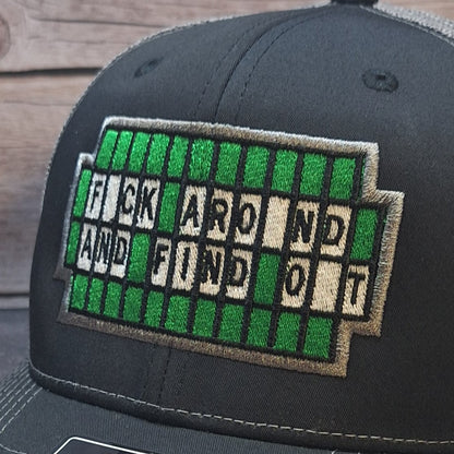 Black cap with a green and white text patch on a wooden surface