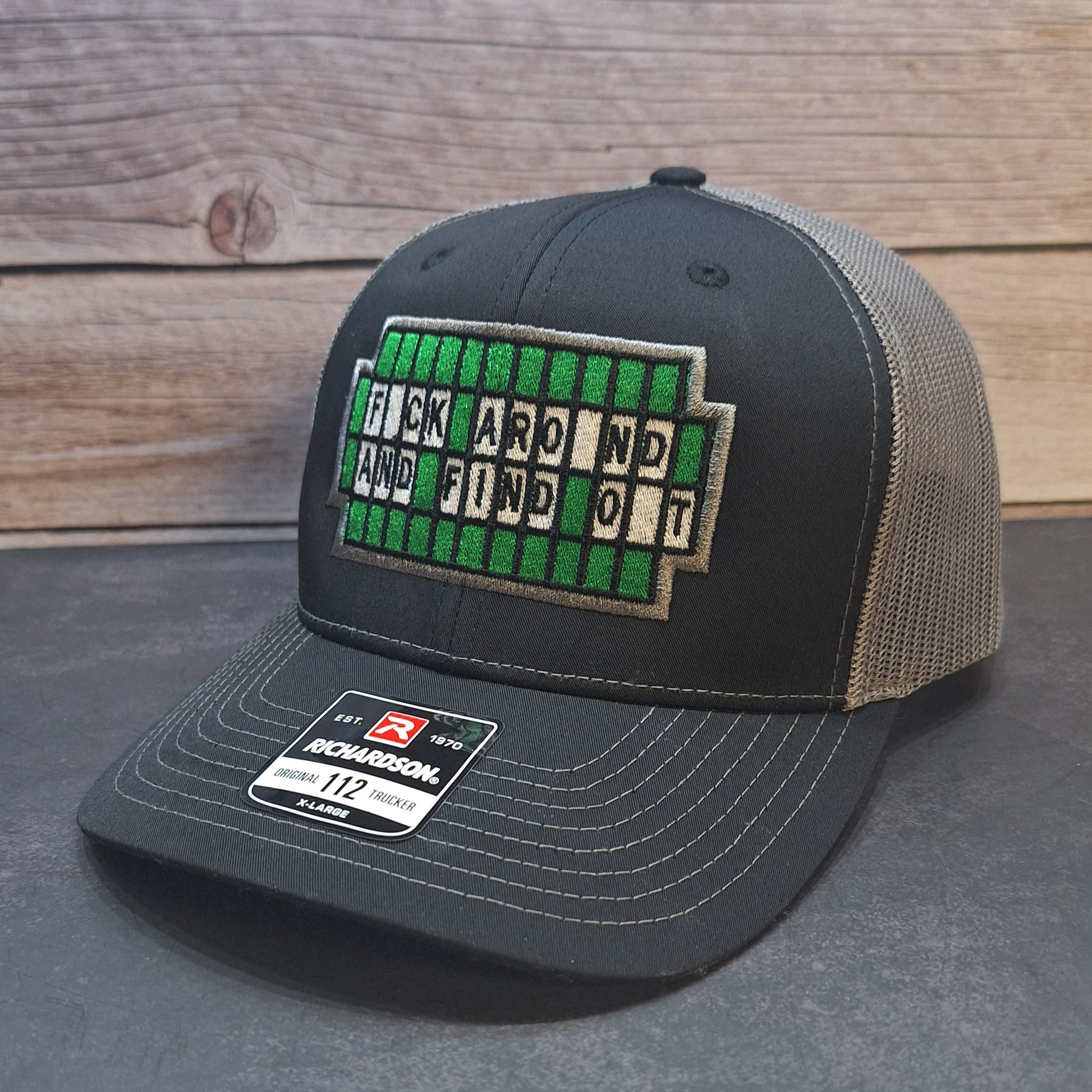 Black and beige cap with a text patch on a wooden surface