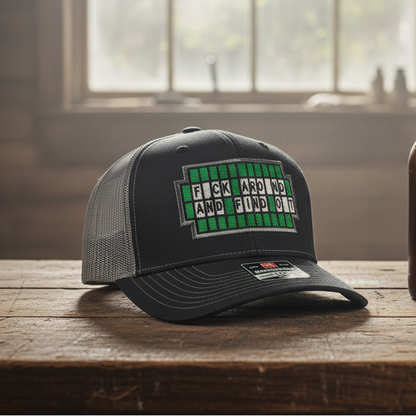 Black cap with green text on a wooden table next to a brown bottle.