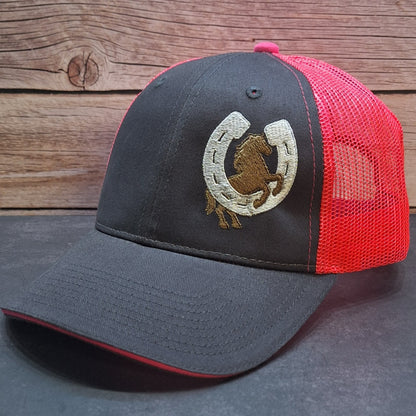Gray and red cap with a horse and horseshoe emblem on a wooden surface