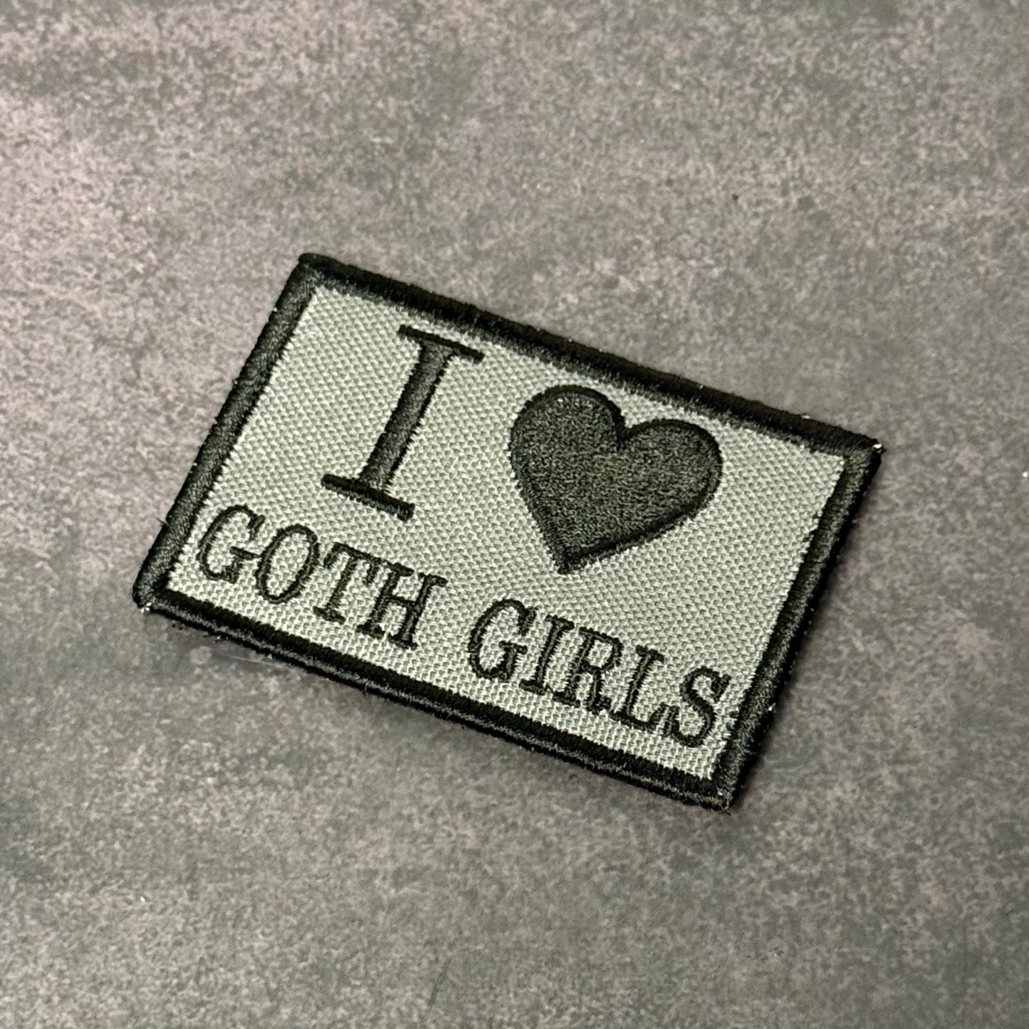 Gray embroidered morale patch with black border featuring the text "I Love Goth Girls" and a black heart symbol on a gray background.