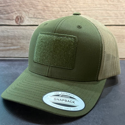 Green snapback cap with a velcro patch on a panel on the front.