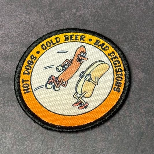 Circular patch with cartoon hot dog and hot dog bun characters and text on a gray background