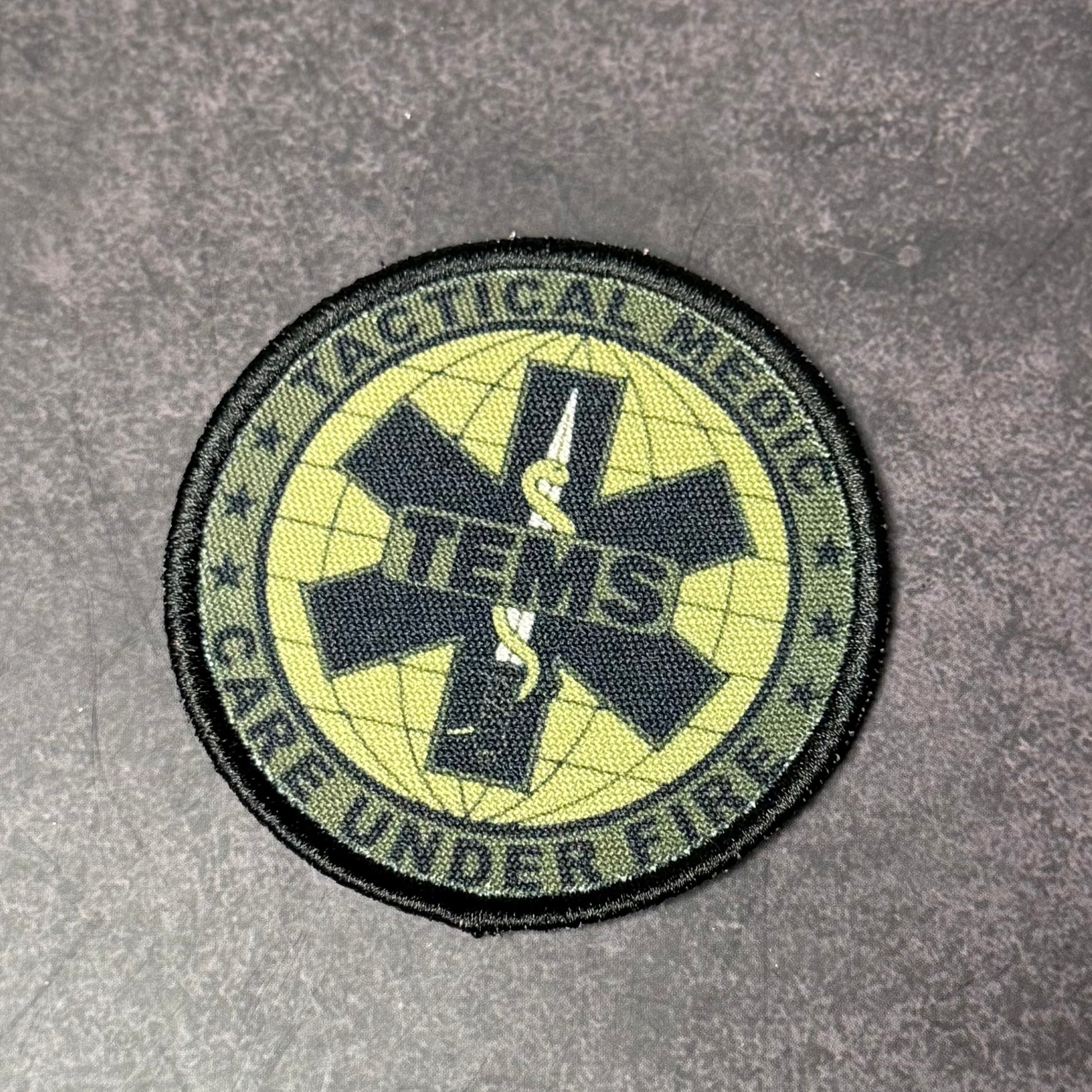Circular patch with tactical and medical symbols on a gray background