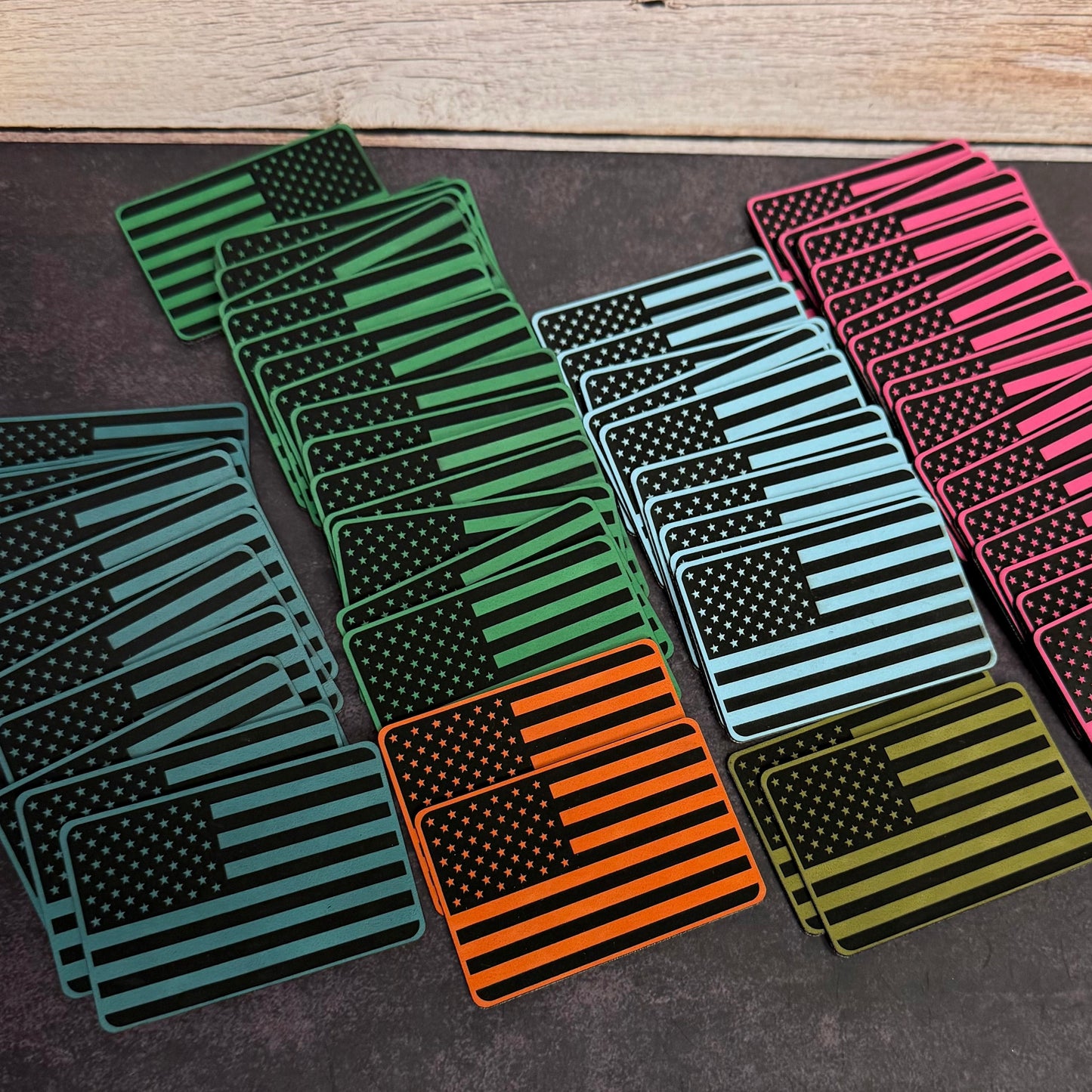 Engraved American flag morale patches with VELCRO hook backing in various colors.