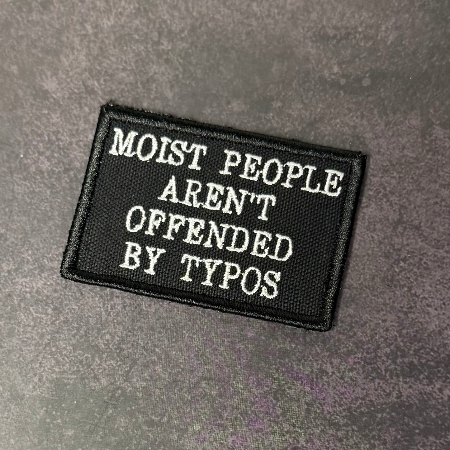 Black patch with white text on a gray background