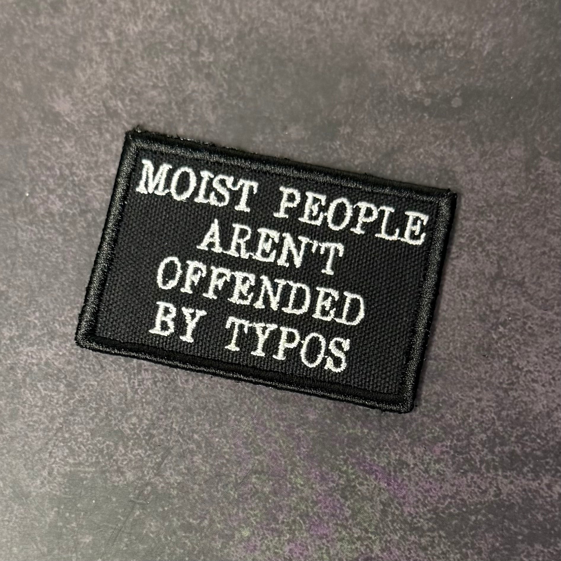 Black patch with white text on a gray background