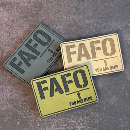 Three rectangular tactical patches with the text 'FAFO' and 'YOU ARE HERE' arranged on a textured gray background.