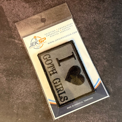A packaged embroidered patch reading 'I <heart> GOTCHA GIRLS' on a dark textured background, mounted on a branded JESP transfer/embroidery card and photographed on a dark stone-like surface.