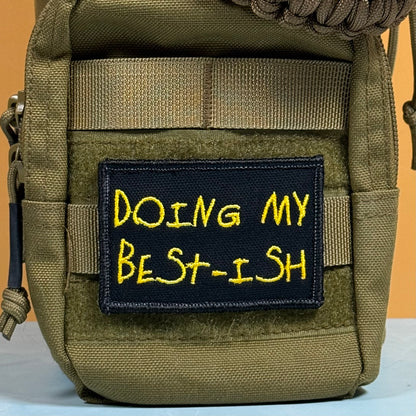 An olive green tactical pouch with a black embroidered patch featuring yellow text that reads 'DOING MY BEST-ISH'.