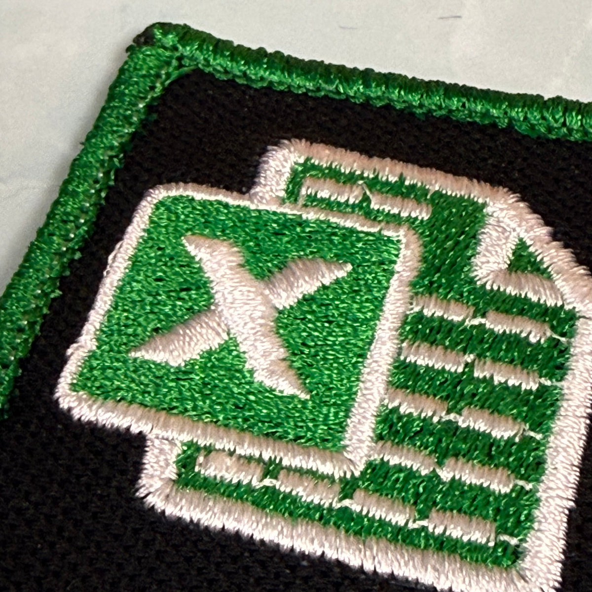 Close-up of an embroidered patch featuring the green Microsoft Excel logo on a black background with a green stitched border.