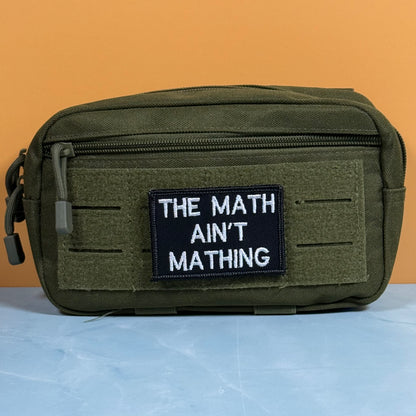 An olive green tactical pouch with a black patch that reads 'THE MATH AIN'T MATHING' in white text, set against a split orange and light blue background.