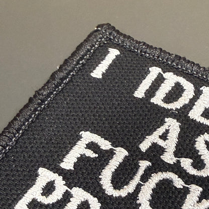 Close-up of a black embroidered patch with white text reading 'I DID AS FUCK' on a neutral gray background.