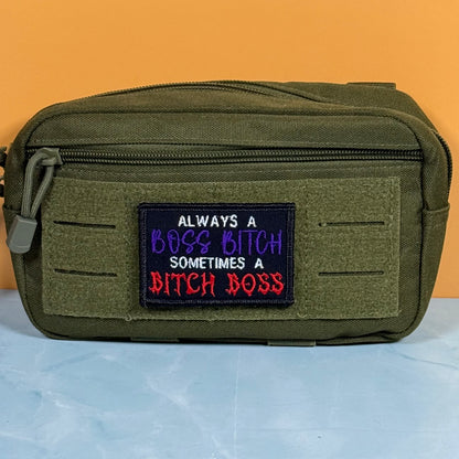 An olive green tactical pouch with a front hook-and-loop patch featuring the embroidered text 'ALWAYS A BOSS BITCH SOMETIMES A BITCH BOSS' in white, purple, and red.