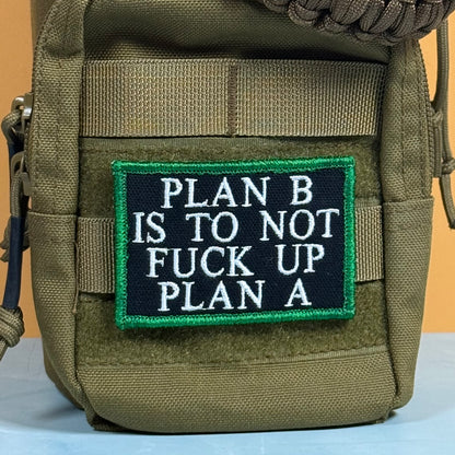 An olive green tactical pouch with a black rectangular patch featuring white embroidered text that reads 'PLAN B IS TO NOT FUCK UP PLAN A' and a green border, shown against a plain background.