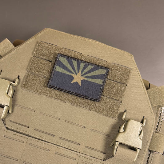 A rectangular Arizona state flag patch mounted on tan tactical gear with hook-and-loop fastening, shown in a close-up studio shot.