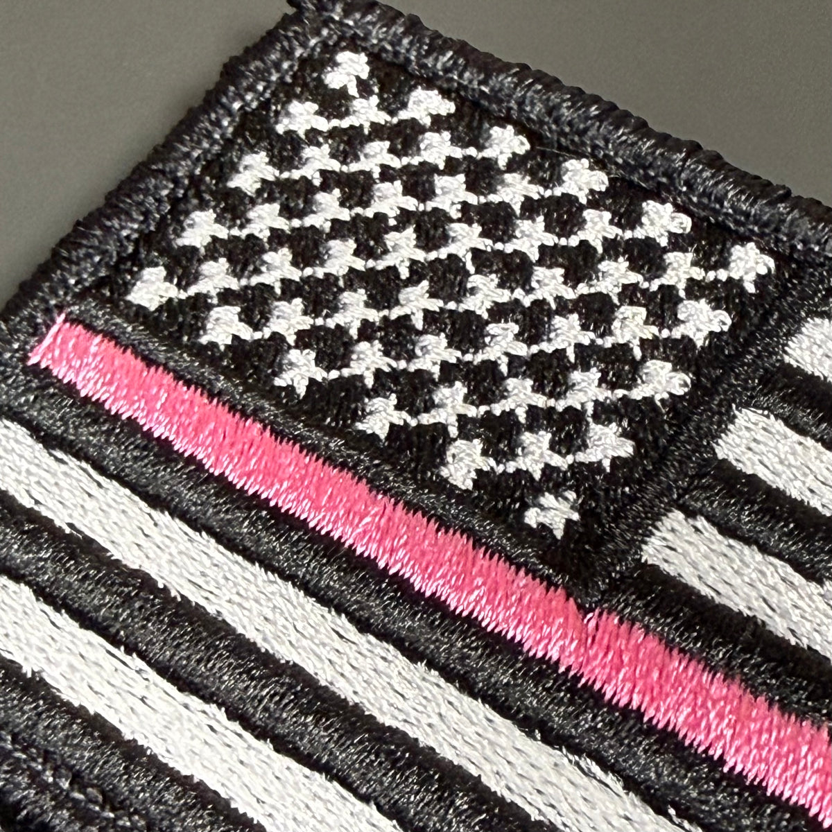 Breast Cancer Awareness Thin Pink Line American Flag embroidered morale patch: embroidered American flag patch in black, white, and pink thread, showing a thin pink line across the stripes.