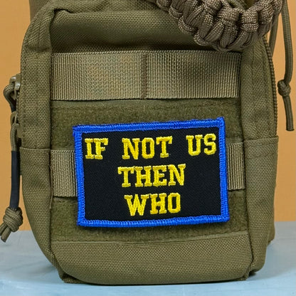 If Not Us Then Who embroidered morale patch: olive green tactical pouch featuring a rectangular embroidered patch with the text 'IF NOT US THEN WHO' in yellow on a black background with a blue border.