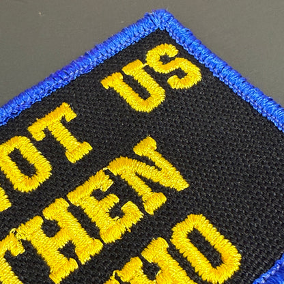 If Not Us Then Who embroidered morale patch: with yellow text reading 'NOT US THEN WHO' on a black background with a blue stitched border.