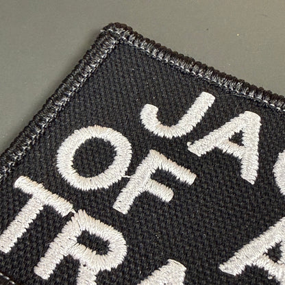 Jack Of All Trades embroidered morale patch: black embroidered patch with white lettering on a gray background.