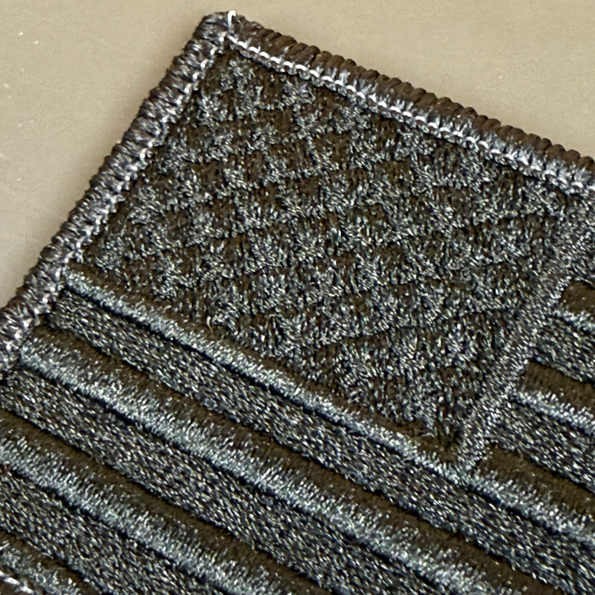 Blackout No Quarters Given American Flag embroidered morale patch: dark embroidered patch with a textured flag design, featuring a black and gray American flag pattern on a beige background.