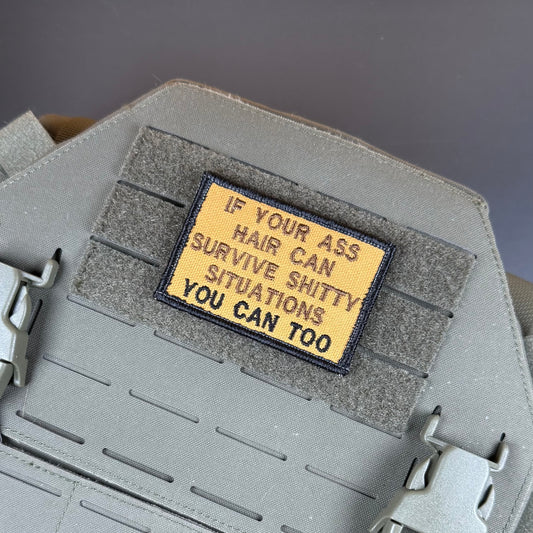 If Your Ass Hair Can Survive embroidered morale patch: embroidered tactical patch with the text 'IF YOUR ASS HAIR CAN SURVIVE SHITTY SITUATIONS YOU CAN TOO' in black on a tan background, shown attached to gray velcro.