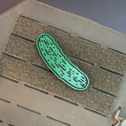 Dill Pickle laser-engraved synthetic morale patch: a green pickle-shaped patch with black dotted details, displayed on a gray tactical vest with a hook-and-loop panel.