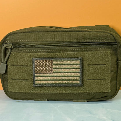 Subdued FDE Tactical American Flag embroidered morale patch: olive green tactical pouch with a front zipper and a rectangular embroidered American flag patch in subdued olive and tan tones, shown against an orange background.