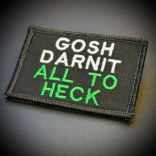 A rectangular black embroidered patch with the text 'GOSH DARNIT ALL TO HECK' in white and bright green lettering, shown on a dark gray background.