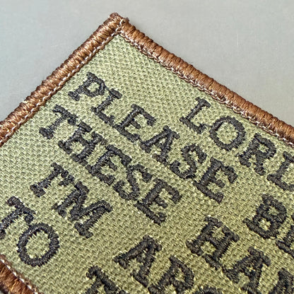 Lord, Bless These Hands I'm About To Throw embroidered morale patch: rectangular embroidered patch with a tan border and olive drab background, featuring dark gray text that reads 'PLEASE THESE HANDS TO LOR.