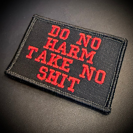 A rectangular black embroidered patch with red text reading 'DO NO HARM TAKE NO SHIT' on a dark textured background.