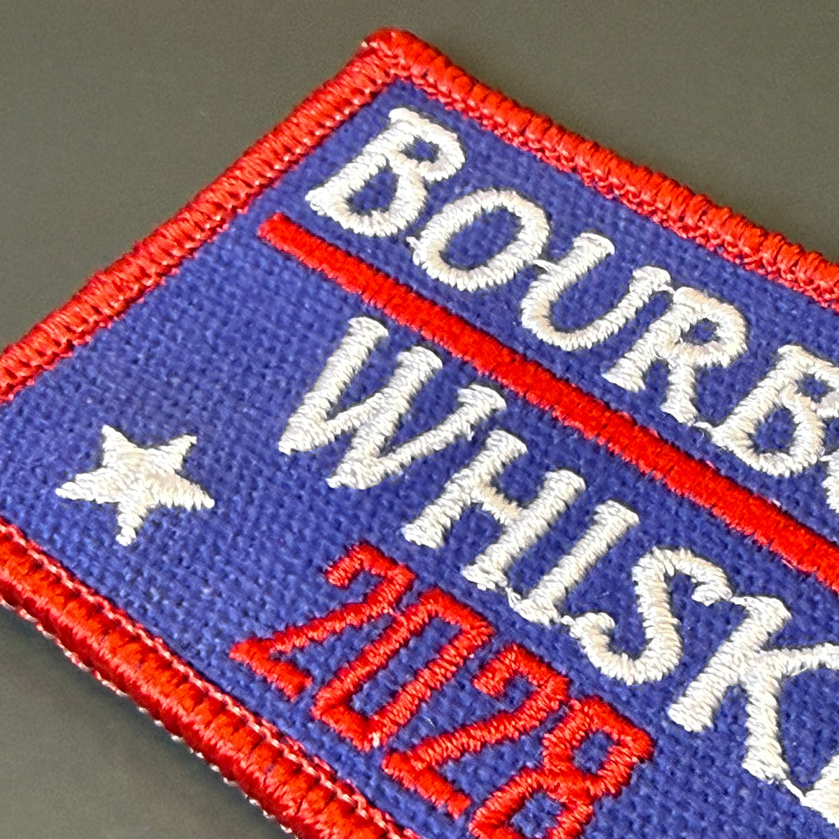 Bourbon & Whiskey for President 2028 embroidered morale patch: embroidered rectangular patch with a blue field, red border and text, and a white star. The visible text reads "BOURB.