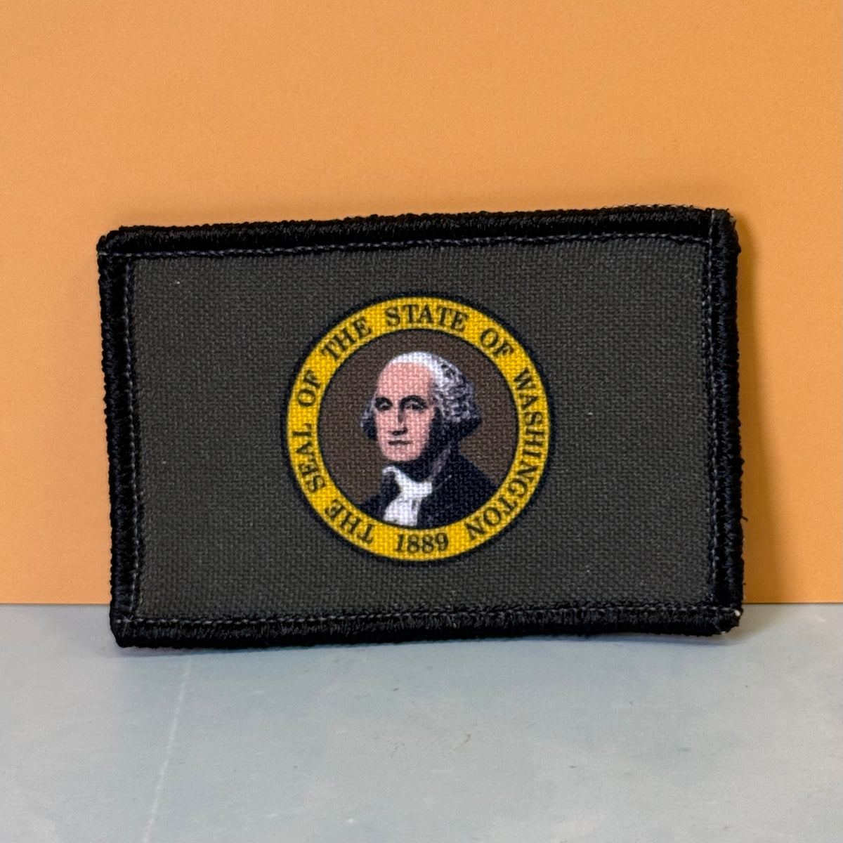 Washington State Flag printed canvas morale patch featuring the State of Washington seal with George Washington's portrait and a yellow border the design lettering.
