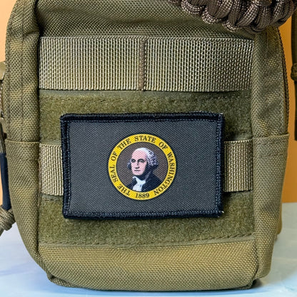 Washington State Flag printed canvas morale patch, an olive drab tactical pouch featuring a rectangular black patch with a yellow circular border and a portrait of George Washington, labeled 'SEAL OF THE STATE OF WASHINGTON 1789'.