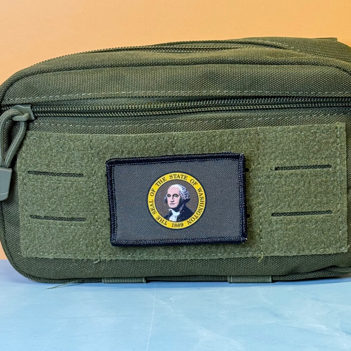 Washington State Flag printed canvas morale patch, an olive green tactical pouch with a black rectangular patch featuring a circular US States of Virginia design with George Washington's portrait.