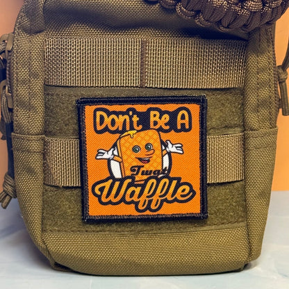 An olive green tactical pouch featuring a square orange patch with a cartoon waffle and the text 'Don't Be A Sweet Waffle'.